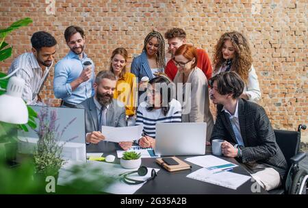 Group of entrepreneurs architects discussing issues indoors in office, working on project. Stock Photo