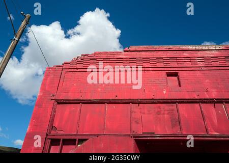 The facade of a crumbling red brick building Stock Photo