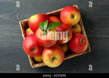 Basket with red apples on dark wooden table Stock Photo