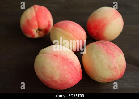 Heap of Fresh Ripe Peaches Scattered on Black Wooden Table Stock Photo