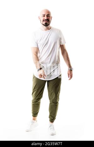 Joyful relaxed young bald stylish man dancing and moving wearing white t-shirt. Full body length isolated on white background Stock Photo