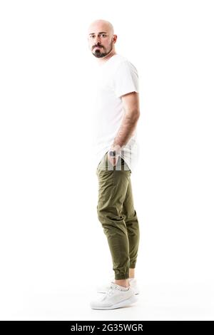 Side view of standing young bald shaven man in chino trousers. Full body length isolated on white background Stock Photo