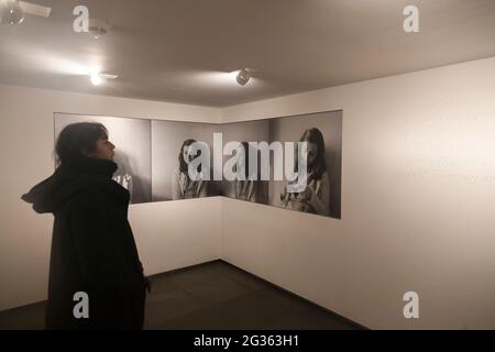 Young woman looking at portraits inside the Anne Frank House Museum in Amsterdam, North Holland, The Netherlands Stock Photo