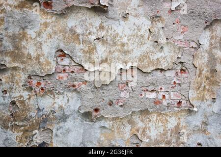 old brick wall with crumbling plaster outdoor closeup. abstract background Stock Photo