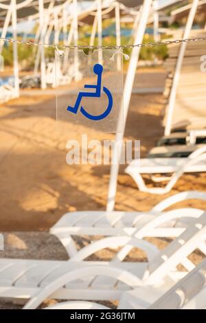 Wheelchair sign showing the sunbeds reserved for disabled people. Sunbeds reserved on the beach for wheelchair users in Antalya, Turkey. Stock Photo
