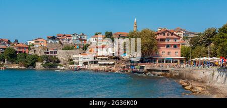 Amasra, Turkey-September 1, 2011: Panoramic view of famous fish restaurants with people having lunch, colorful hoouses and coastal near Amasra beach.. Stock Photo