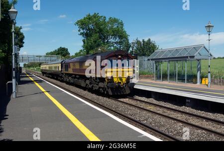 EWS class 66 diesel locomotive pulling two preserved railway carriages at Tackley railway station, Oxfordshire, England, UK Stock Photo