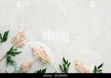 Natural Summer background with border of wild flowers. Copy-space, place for text. Flat lay on off white linen background with pale pink wild Stock Photo