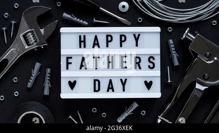 Happy Fathers Day banner concept.Working repair tools upholstery stapler,screwdriver,screws,adjustable wrench,duct tape and light box with Happy Fathe Stock Photo
