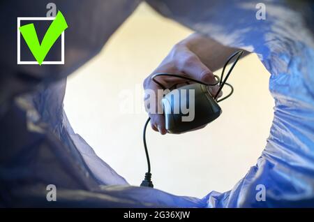 Wireless technology concept. A woman's hand throws a computer mouse in the trash.Close up. Stock Photo