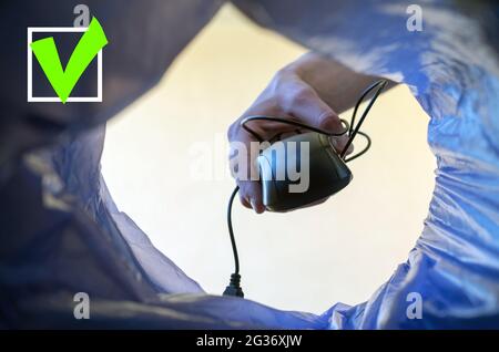 Wireless technology concept. A woman's hand throws a computer mouse in the trash.Close up. Stock Photo