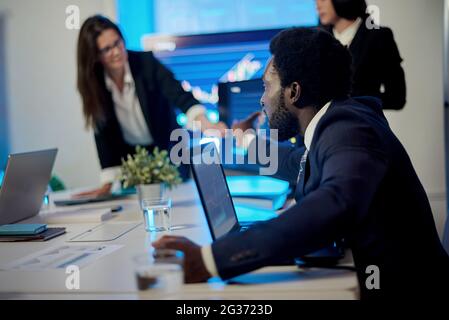 Crop multiracial employees working at table with laptops in office Stock Photo