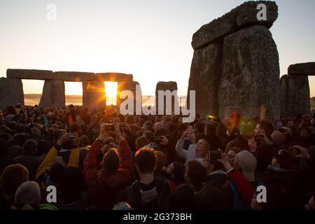 People welcoming the first rays of sunshine on the longest day of the year. --- The 21st of June is the day of the summer solstice. It is the longest Stock Photo