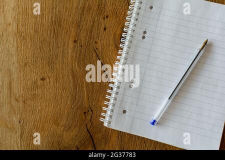 Close up of a blank notebook with a pen on wooden background Stock Photo