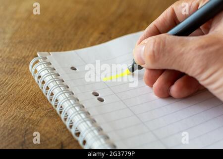 Male handwriting with yellow marker pen drawing on a notebook Stock Photo