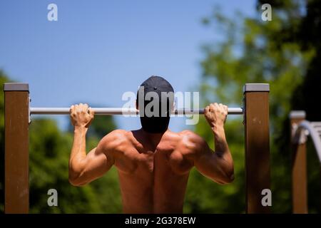 Cologne, Germany. 14th June, 2021. An athlete does pull-ups at an outdoor gym in a park in Cologne. Credit: Rolf Vennenbernd/dpa/Alamy Live News Stock Photo