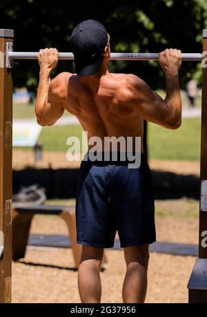 Cologne, Germany. 14th June, 2021. An athlete does pull-ups at an outdoor gym in a park in Cologne. Credit: Rolf Vennenbernd/dpa/Alamy Live News Stock Photo