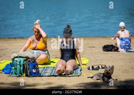 London, UK.  14 June 2021.  UK Weather – People sunbathe on the beach at Ruislip Lido in north-west London.  The forecast is for the temperature to rise to 28C, the hottest day of the year so far. Credit: Stephen Chung / Alamy Live News Stock Photo