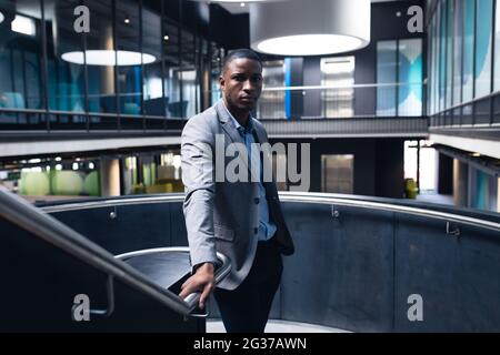 Portrait of african american businessman standing on the stairs at modern office Stock Photo