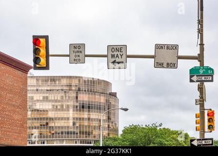 Multiple traffic signs at an intersection with buildings in the background. Stock Photo