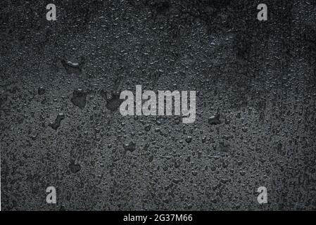 Wet black stone background. Water drops or condensation on dark stone surface close up. Stock Photo