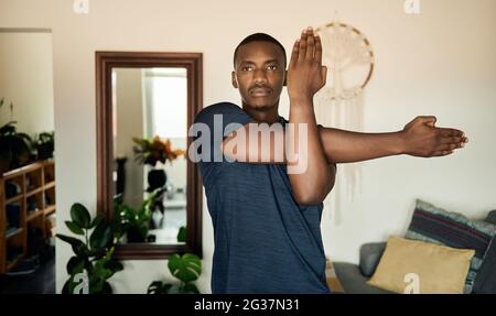 Fit young African man warming up before a home workout Stock Photo