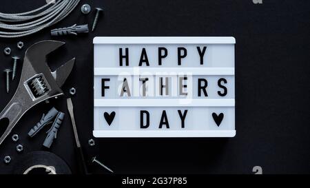 Happy Fathers Day banner concept.Working repair tools upholstery stapler,screwdriver,screws,adjustable wrench,duct tape and light box with Happy Fathe Stock Photo