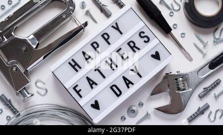 Happy Fathers Day banner concept.Working repair tools upholstery stapler,screwdriver,screws,adjustable wrench,duct tape and light box with Happy Fathe Stock Photo