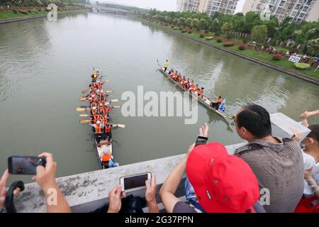 (210614) -- SHANGHAI, June 14, 2021 (Xinhua) -- People watch a dragon boat race to celebrate the Dragon Boat Festival in Huacao Township, Minhang District, east China's Shanghai, June 14, 2021.  China celebrated the Dragon Boat Festival on Monday to commemorate Qu Yuan, a patriotic poet from the Warring States Period (475-221 BC).     People race dragon boats and eat Zongzi, a sticky rice dumpling wrapped up with bamboo or reed leaves during the festival. (Xinhua/Wang Xiang) Stock Photo