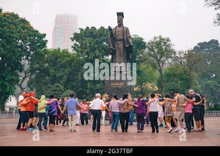 Hanoi, Vietnam - April 8, 2016: Vietnamese people practice sport exercise early in the morning on the bank of Hoan Kiem lake Stock Photo