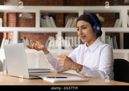 Concentrated millennial indian woman holding distant video call conversation. Stock Photo