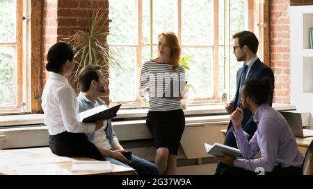 Professional female team leader presenting business ideas to colleagues. Stock Photo