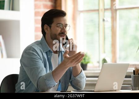 Young serious skilled male manager holding distant conversation. Stock Photo