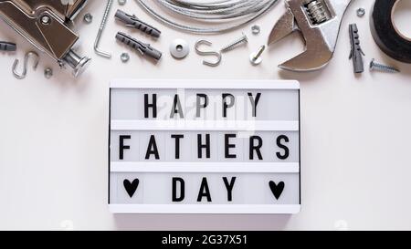Happy Fathers Day banner concept.Working repair tools upholstery stapler,screwdriver,screws,adjustable wrench,duct tape and light box with Happy Fathe Stock Photo
