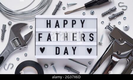 Happy Fathers Day banner concept.Working repair tools upholstery stapler,screwdriver,screws,adjustable wrench,duct tape and light box with Happy Fathe Stock Photo