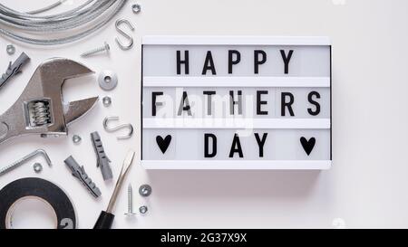 Happy Fathers Day banner concept.Working repair tools upholstery stapler,screwdriver,screws,adjustable wrench,duct tape and light box with Happy Fathe Stock Photo