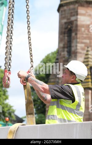 Builder working to attach lifting chains from a crane June 2021 Stock Photo