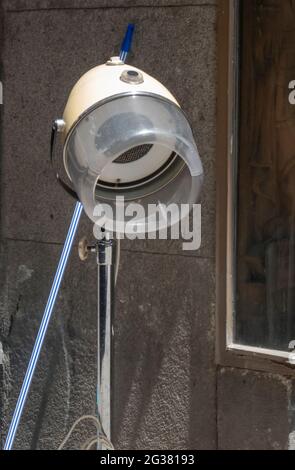 Vintage helmet dryer decorating the exterior of a store in town Stock Photo