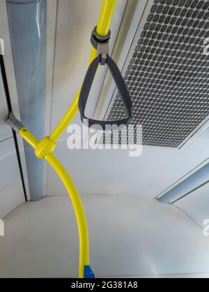 Interior of a city bus, with handrails and hanging handles Stock Photo