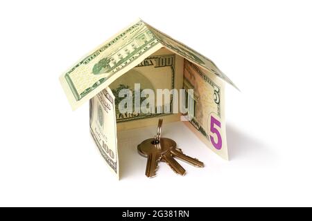 bunch of keys inside a house made from dollar banknotes on white background Stock Photo