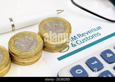 A financial still-life with Pound coins , calculator, pen and glasses on a Uk tax return form. Stock Photo