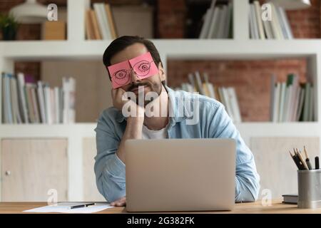 Exhausted young caucasian male manager feeling bored. Stock Photo