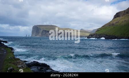 Risin and Kellingin rocks as seen from Tjornuvik bay with waves hitting the shore on Streymoy on the Faroe Islands, Denmark, Europe Stock Photo