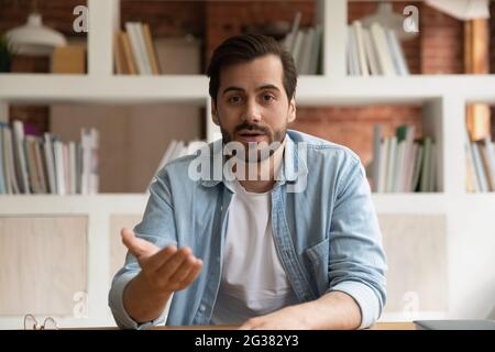 Young handsome man talking looking at camera. Stock Photo