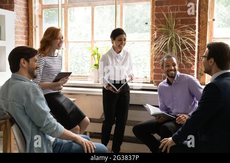Laughing young indian business lady having fun with diverse colleagues. Stock Photo