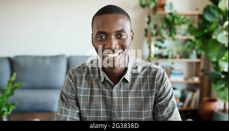 Smiling young African man working from home in his living room Stock Photo