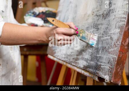 Close-up of an unrecognizable woman painter doing a brush stroke. High quality photo. Stock Photo