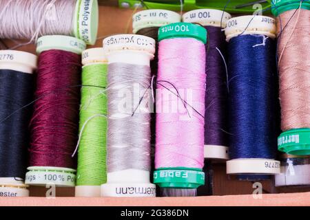 Spools with colorful threads on desk. Tailoring work Stock Photo
