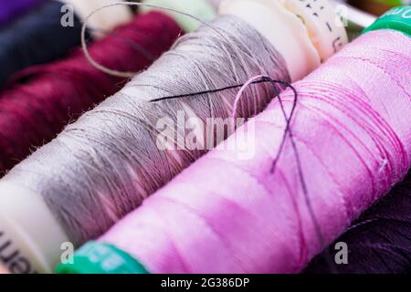 Spools with colorful threads on desk. Tailoring work Stock Photo