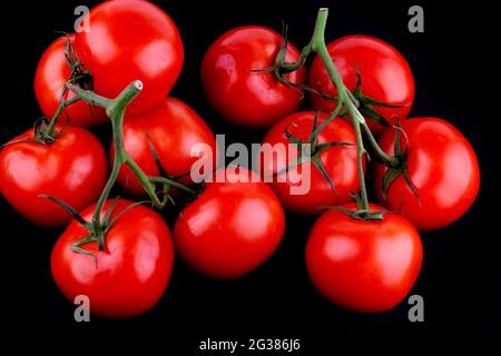 Red Tomato with Stem,isolated on black. The tomato is the edible berry of the plant Solanum lycopersicum, commonly known as a tomato plant. Andalucia, Stock Photo